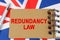 Against the background of the flag of Great Britain lies a notebook with the inscription - REDUNDANCY LAW