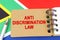 Against the background of the flag of South Africa lies a notebook with the inscription - ANTI DISCRIMINATION LAW