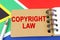 Against the background of the flag of South Africa lies a notebook with the inscription - COPYRIGHT LAW