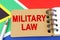 Against the background of the flag of South Africa lies a notebook with the inscription - MILITARY LAW