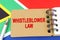 Against the background of the flag of South Africa lies a notebook with the inscription - WHISTLEBLOWER LAW