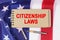 Against the background of the flag of the USA lies a notebook with the inscription - CITIZENSHIP LAWS