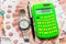 Against the background of Russian five-thousandth bills lies a calculator with the number one million, a watch and a pen