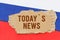 Against the background of the Russian flag lies cardboard with the inscription - Todays News