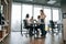 Against big windows by the table. Four people are working in the office together