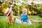 Age mother with a small daughter lying on the lawn in the park and blowing soap bubbles. Summer, vacation, maternity leave,