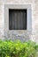 Aged architecture window and green bush