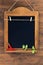 Aged blackboard with chilli peppers and parsley hanging on wooden wall