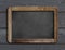 Aged blackboard hanging on black wooden wall 3d illustration