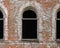 Aged brick wall with arched bricked up windows