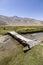 Aged bridge over a small river in Bulunkul in the Pamir mountains