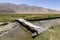 Aged bridge over a small river in Bulunkul in the Pamir mountains in Tajikistan