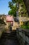 Aged buildings by stone stairway on slope in sunny spring morning