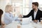 Aged businesswoman shaking hands with client sitting together in boardroom