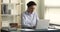 Aged businesswoman sit at desk work on laptop take notes