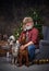 Aged canine pets owner sitting on armchair around christmas tree