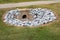 Aged cast concrete headwall for storm water runoff surrounded by new rocks, environmental safety, green grass copy space