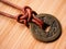 Aged Chinese Coin on Brown Leather Cord Macro Wood Background