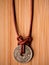 Aged Chinese Coin on Brown Leather Cord Macro Wood Background