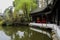 Aged Chinese gallery by water in spring