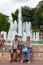 Aged disabled people sit together outdoors by fountain on sea embankment of Anapa city resort