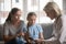 Aged doctor holding clipboard filling little patient information form