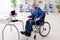 The aged employee in wheelchair working in the office