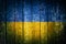 Aged flag Ukraine is depicted on an old wooden background