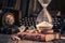 Aged journal and hourglass with binocular, compass and books