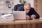 Aged male bookkeeper sitting at workplace