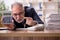 Aged male bookkeeper sitting at workplace