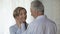 Aged male cupping woman cheek putting his forehead against hers, loving feelings