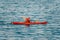 Aged Male kayaker in a red kayak on the background of the sea. Copy space. The concept of travel, relaxation, active and healthy