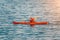 Aged Male kayaker in a red kayak on the background of the sea. Copy space. The concept of travel, relaxation, active and healthy