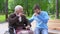 Aged male in wheelchair and volunteer laughing and joking, having fun together