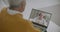 Aged man is conducting online webinar and retired person is watching him on screen of his laptop, sitting at home