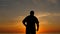 Aged man expressing joy with hand up at sunset slow motion silhouette