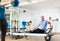 Aged man practicing pilates on reformer tower equipment in sports hall