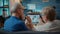 Aged man and woman talking to dentist on online video call