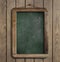 Aged menu blackboard hanging on wooden wall