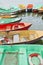 Aged multi colored row boats moored in a lake.