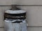 Aged outdoor metal broken grey trash waste bin