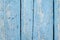 Aged painted cracked boards with blue color peeling paint. Old natural grunge textured wooden texture. Weathered wood wall for