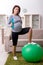 The aged pregnant woman doing exercises at home