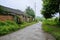 Aged red-brick dwelling houses along countryroad after rain