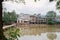 Aged riverside dwelling buildings in early cloudy autumn morning