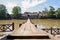 Aged stone beam bridge across river in sunny autumn