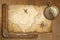 Aged treasure map, ruler and old gold compass on wooden table