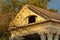 Aged and weathered building roof facade with double gable style and white wooden exterior with gray tiles on top