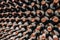 Aged wine bottles stacked up in old wine cellar close-up background